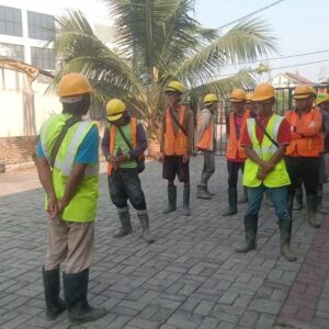 Pekerja dengan helm dan APD KMP